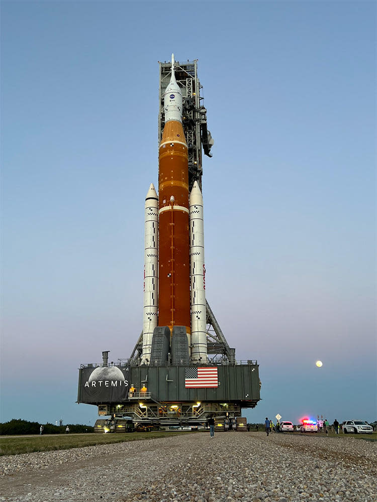 The rising moon provides a fitting backdrop for the SLS rocket and Orion crew capsule as they are hauled to launch pad 39B for a dress-rehearsal countdown.  / Credit: NASA