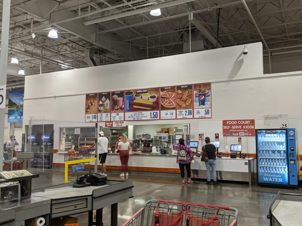 Registers and shopping cart in front of customers at food court at Costco