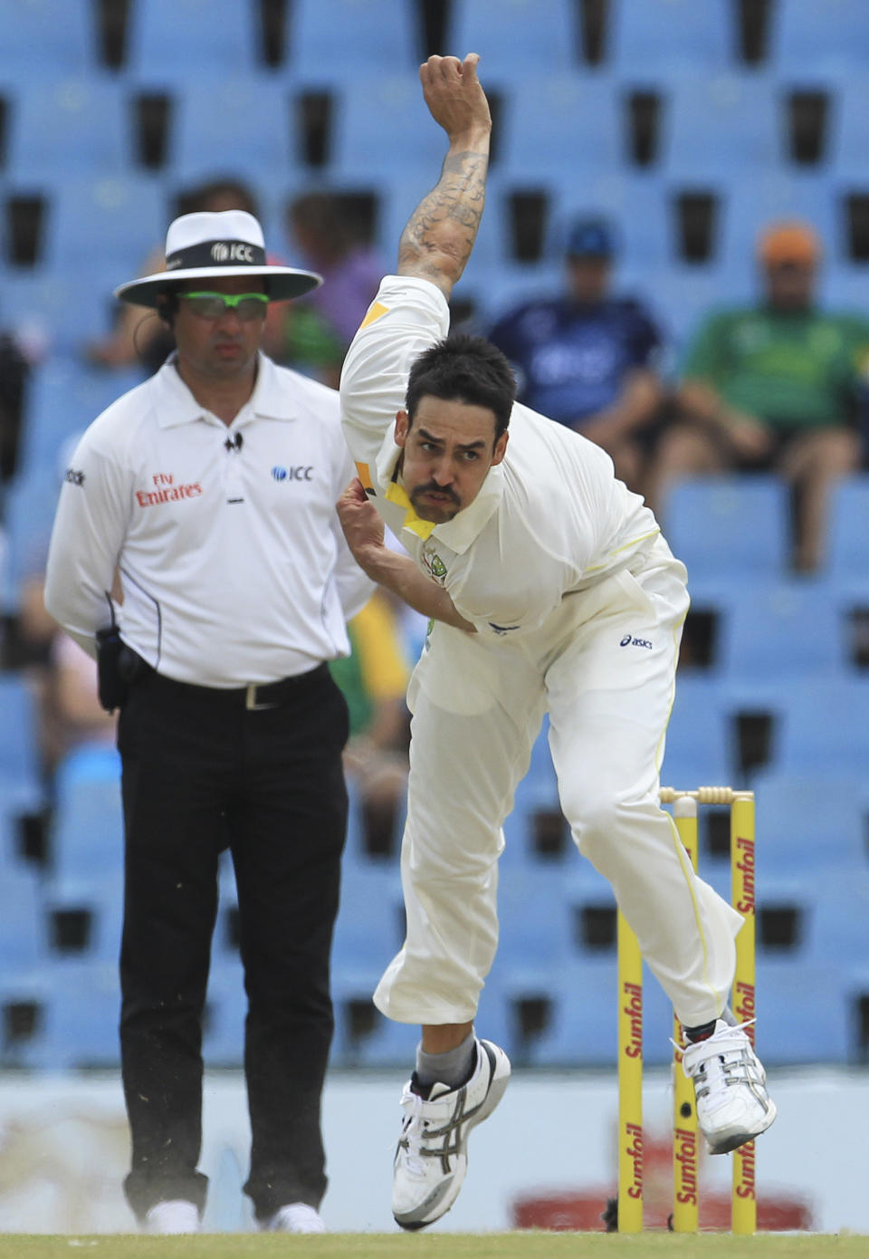 Australia's bowler Mitchell Johnson follows through his delivery against Australia as umpire Aleem Dar of Pakistan, left, watches him on the fourth day of their cricket test match at Centurion Park in Pretoria, South Africa, Saturday, Feb. 15, 2014. (AP Photo/ Themba Hadebe)