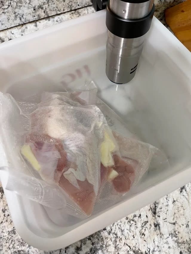 vacuum sealed turkey breasts in a sous vide water bath