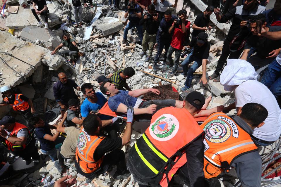 Rescue workers pull surivors from the rubble of the Abu al-Auf building (Anadolu Agency via Getty)