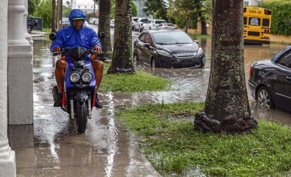 Oscar Gonzalez rides his motorcycle to avoid the flooded street along N.E. 23rd Street in Miami, on Wednesday, June 12, 2024. (Al Diaz/Miami Herald via AP)