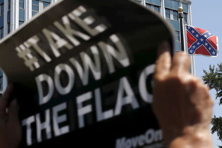 A demonstrator holds a sign at a rally outside the State House to get the Confederate battle flag (R) removed from the grounds in Columbia, South Carolina June 23, 2015. REUTERS/Brian Snyder