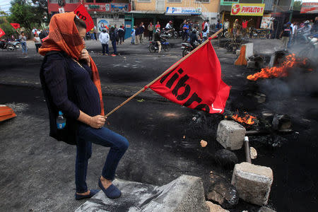 A supporter of Salvador Nasralla, presidential candidate for the Opposition Alliance Against the Dictatorship, stands at a barricade settled to block road during a protest caused by the delayed vote count for the presidential election in Tegucigalpa, Honduras December 1, 2017. REUTERS/Jorge Cabrera