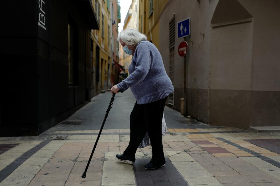 An elderly woman, wearing a face mask, walks in Nice, on the French Riviera in southern France, on April 22, 2020, on the 37th day of a strict lockdown aimed at curbing the spread of the COVID-19 pandemic , caused by the novel coronavirus. (Photo by VALERY HACHE / AFP) (Photo by VALERY HACHE/AFP via Getty Images)