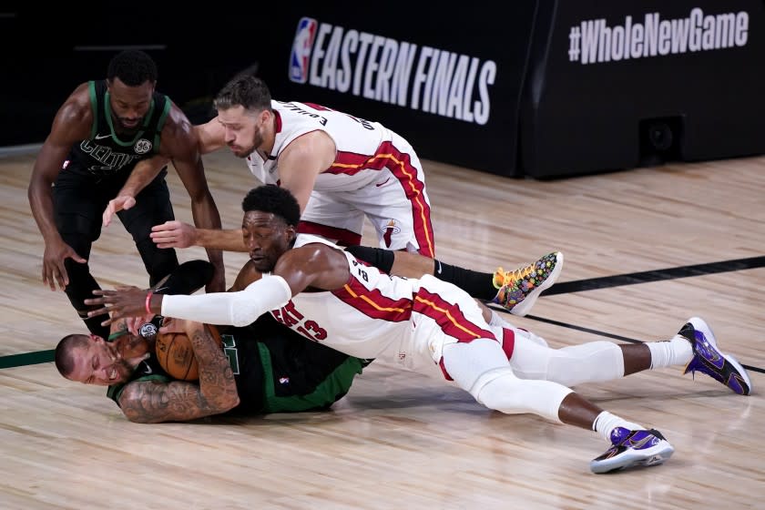 Boston Celtics' Kemba Walker, top left, and center Daniel Theis, bottom left, attempt to gain control of a loose ball.