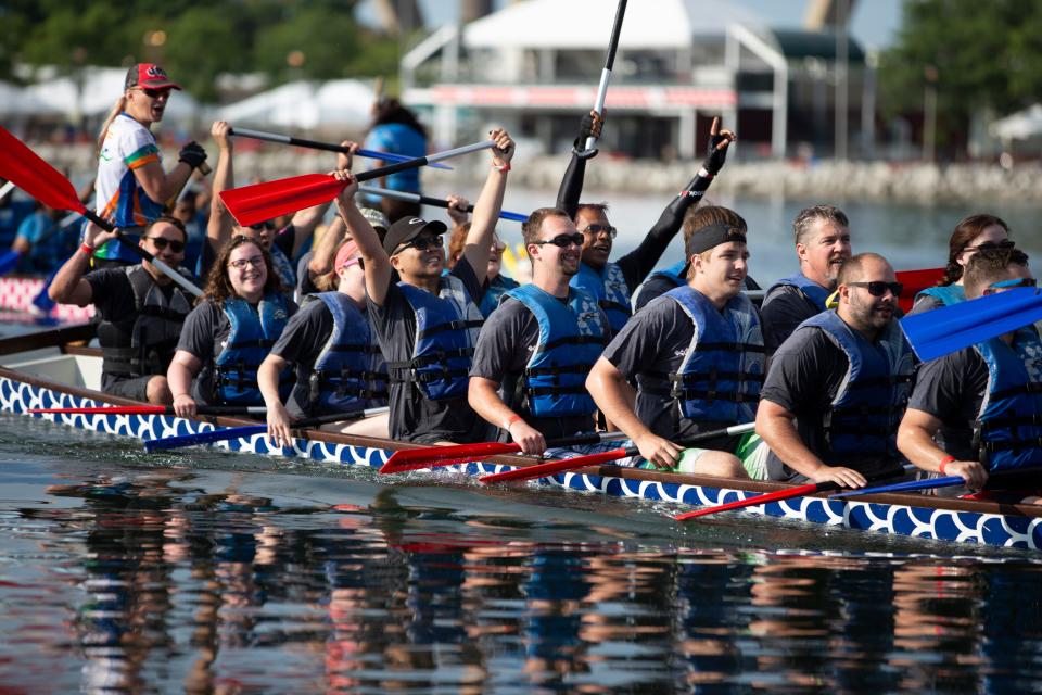 Competitors celebrate after winning their race at the seventh annual Milwaukee Dragon Boat Festival held at Lakeshore State Park in Milwaukee, Wisconsin on Saturday, August 10, 2019.