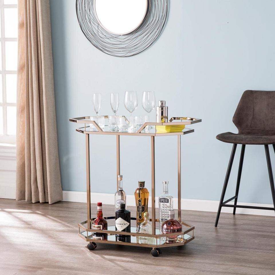 Here's a toast to this bar cart, which definitely feels like it belongs on the set of "<a href="https://www.huffpost.com/entry/art-deco-furniture-decor-online-affordable_l_5f6a58e8c5b6718910f24321" target="_blank" rel="noopener noreferrer">The Great Gatsby</a>." This mirror bar cart even has a <i>champagne</i> finish. And with wheels, you can easily move it around whenever the party's over. <a href="https://fave.co/2GGcTyH" target="_blank" rel="noopener noreferrer">Originally $216, get it now for $130 at The Home Depot</a>.