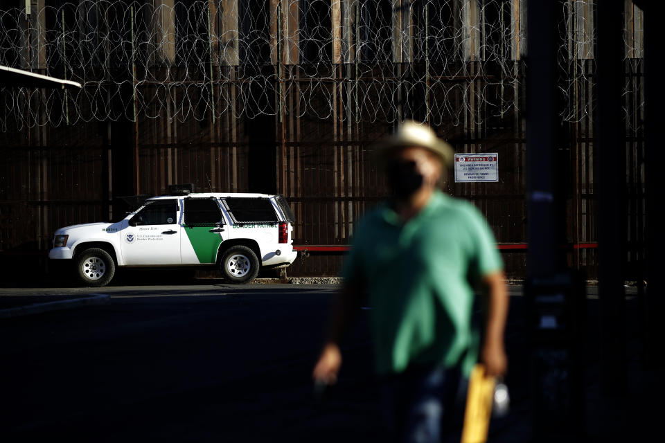 A Border Patrol vehicle sits near the border wall separating Mexicali, Mexico from Calexico, Calif., Tuesday, July 21, 2020, in Calexico. The city of 1 million just to the south brings tens of thousands of people daily to cross. Janette Angulo, Imperial County's public health director, estimates the population doubles during the day in winter, making the official count deceptively low. (AP Photo/Gregory Bull)