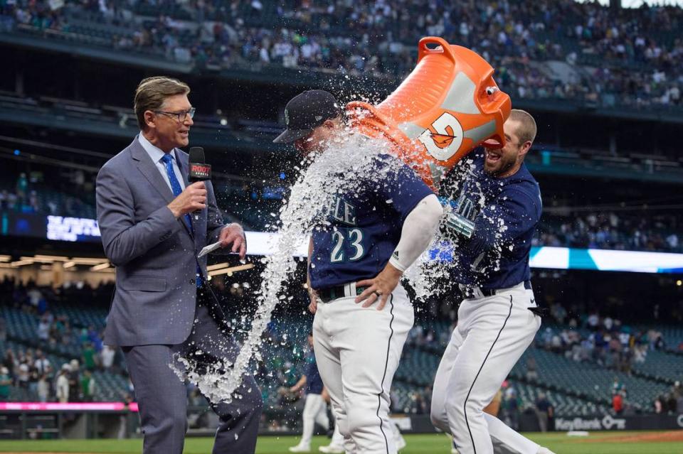 Seattle Mariners’ Ty France is doused with ice water by Tom Murphy as he is interviewed after the team’s 3-2 win over the Oakland Athletics in a baseball game Thursday, May 25, 2023, in Seattle. (AP Photo/John Froschauer)