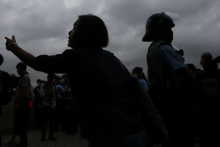 A woman reacts near police following a day of violence in Hong Kong