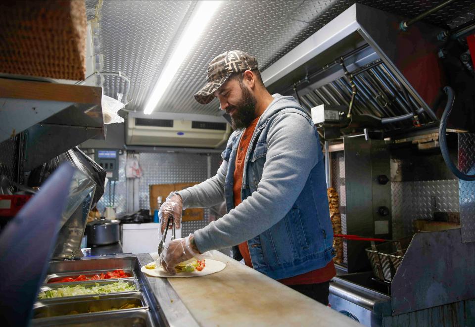 Ahmed Aldoori, an Iraqi immigrant and owner of the new Heisenberg Mediterranean food truck, prepares a meal on Friday, Nov. 12, 2021, at a location in Clive. Aldoori has been working with Catholic Charities and USCRI to provide hot meals to Afghan evacuees when they arrive to Des Moines. 