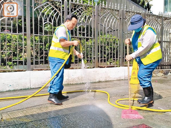 清潔工清理寺外殘留水劑痕迹。（王鏡文攝）