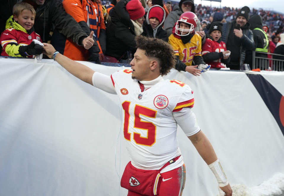 Kansas City Chiefs quarterback Patrick Mahomes hands a piece of his equipment to a fan after an NFL football game against the Denver Broncos, Sunday, Oct. 29, 2023, in Denver. (AP Photo/David Zalubowski)