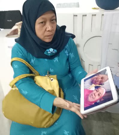 Carmalia Baunto, 42, shows an image of herself and her husband, Nixon Baunto, who is trapped inside the besieged town of Marawi City, Philippines June 21, 2017. Picture taken June 21, 2017. REUTERS/Simon Lewis