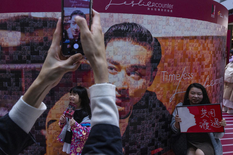 Fans take photographs during an event commemorating the 20th anniversary of the death of Canto-pop singer Leslie Cheung at a shopping mall in Hong Kong, Friday, March 31, 2023. Fans of Cheung, one of the first singers to come out as gay in Hong Kong, flocked to the city this week to commemorate their idol’s death 20 years ago, revisiting his legacy of pioneering work made during a socially conservative time. (AP Photo/Louise Delmotte)