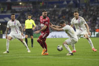 Brest's Romain Del Castillo, second from left, is challenged by Lyon's Nicolas Tagliafico during a French League One soccer match between Lyon and Brest at the Groupama stadium, outside Lyon, France, Sunday, April 14, 2024. (AP Photo/Laurent Cipriani)