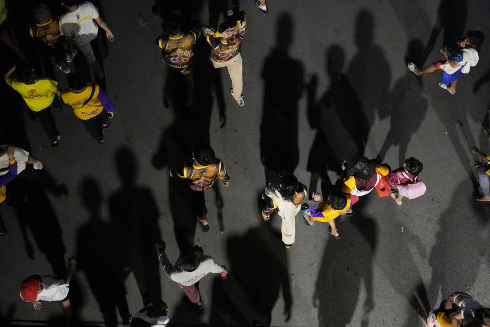 Devotees join the "Walk of Faith" procession as part of celebrations for the feast day of the Black Nazarene, a centuries-old charred statue of Jesus Christ, on Sunday, Jan. 8, 2023, in Manila, Philippines. The annual Black Nazarene feast day which will be held on Jan. 9 draws massive numbers of devotees who pray for the sick and a better life in this predominantly Roman Catholic nation. (AP Photo/Aaron Favila)