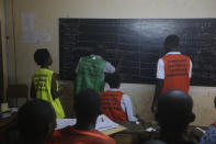 Electoral officials tally results at the end of voting in one of the polling stations in Lome, Togo Saturday, Feb. 22 2020. The West African nation of Togo is voting Saturday in a presidential election that is likely to see the incumbent re-elected for a fourth term despite years of calls by the opposition for new leadership (Photo/ Sunday Alamba)