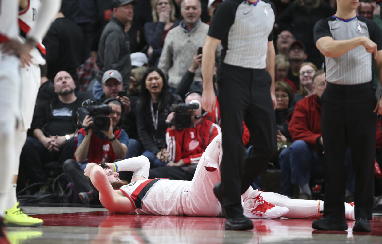 Portland Trail Blazers center Jusuf Nurkic, on ground, was injured and left the court on a stretcher as the Blazers beat the Brooklyn Nets in double overtime, 148-144, during an NBA basketball game in Portland, Ore., Monday, March 25, 2019. (AP Photo/Randy L. Rasmussen)