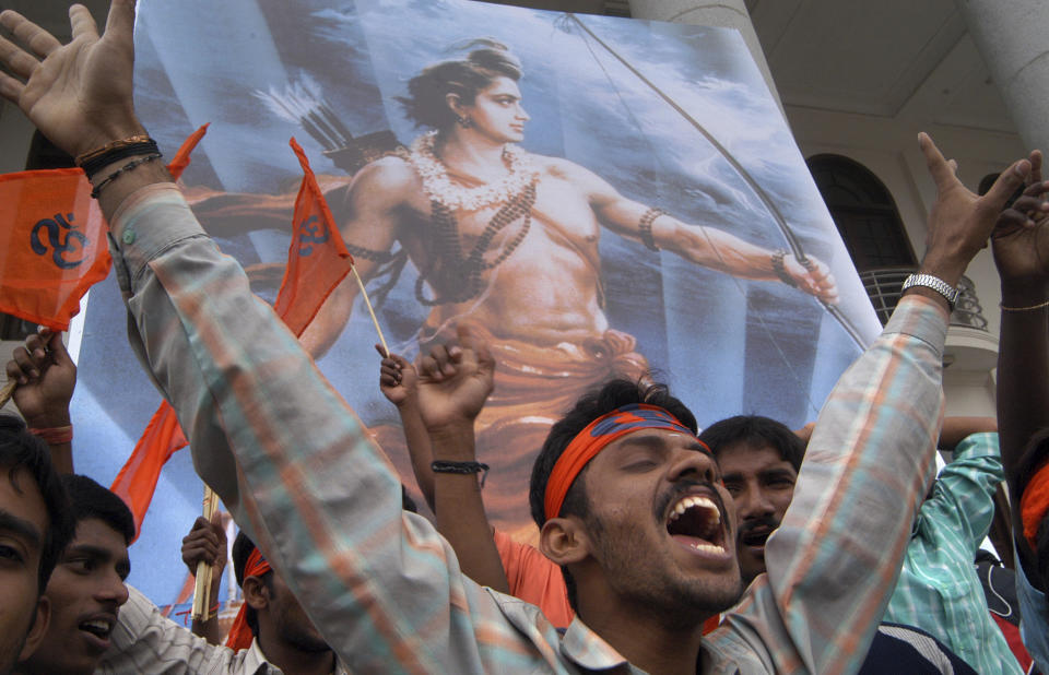 FILE - Standing before a poster of the Hindu deity Ram, a Vishwa Hindu Parishad (World Hindu Council) member shouts slogans during a rally to protest against the raid on a Hindu temple in northern India, in Gauhati, India, July 7, 2005. While the slogan "Jai Sri Ram," or "Hail Lord Ram," has become a political battle cry for Hindu nationalists, "Ram-Ram" remains a popular way of greeting across rural India. (AP Photo/Gautam Singh, File)