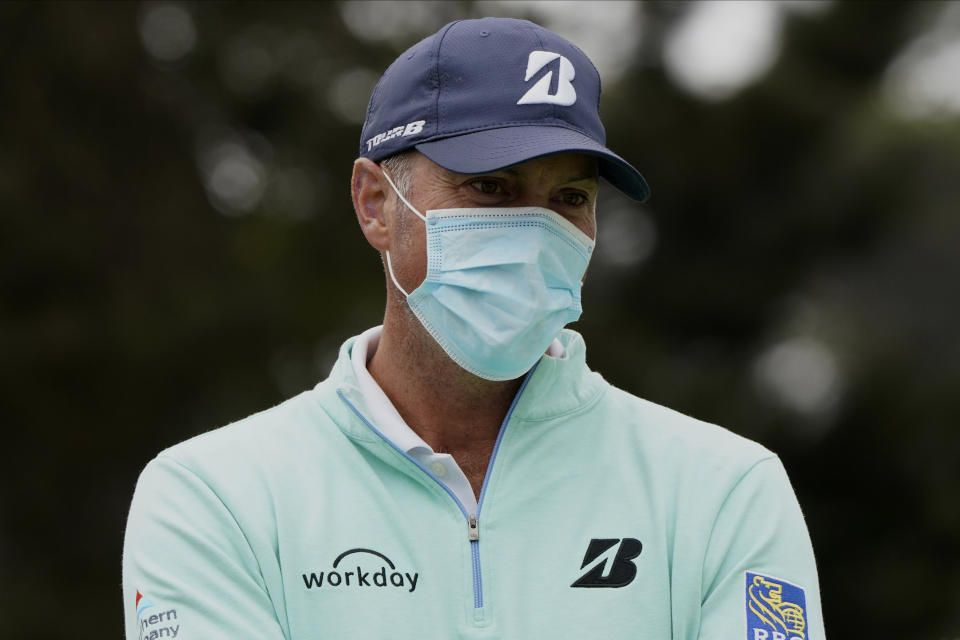 Matt Kuchar wears a face mask while talking at the driving range during practice for the PGA Championship golf tournament at TPC Harding Park Wednesday, Aug. 5, 2020, in San Francisco. (AP Photo/Charlie Riedel)