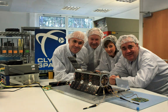 Clyde Space scientists, the proud parents of Scotland’s first satellite, UKube-1, pose with the small spacecraft, which is set to launch in 2013.