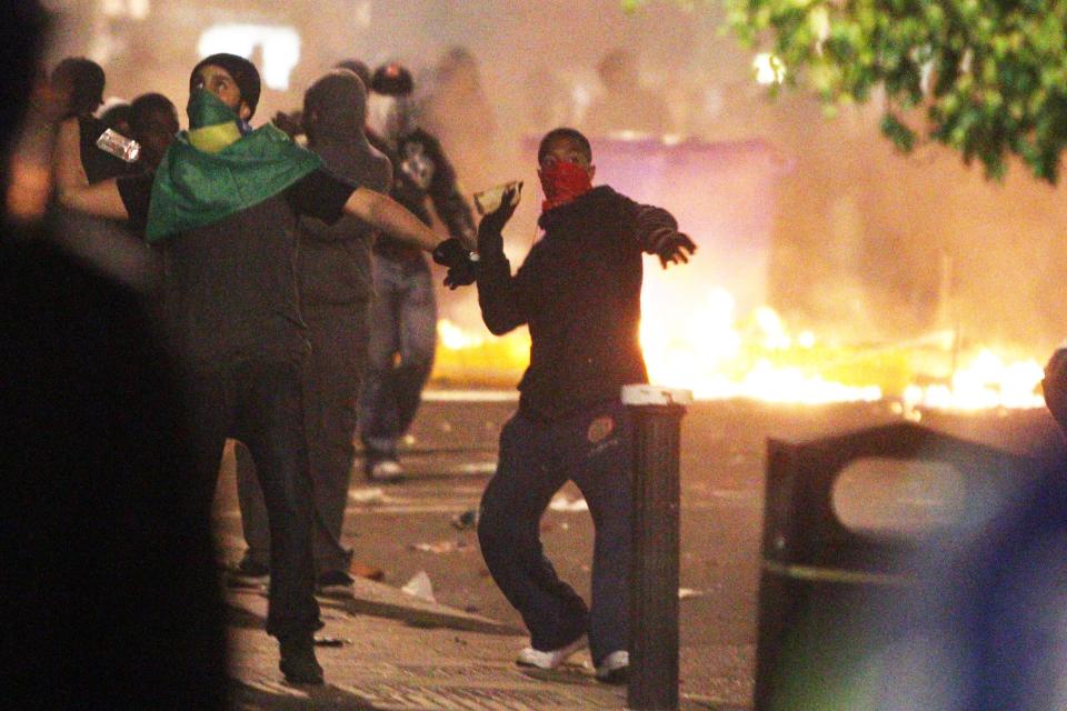 Youths throw objects at riot police during the first night of the summer riots, in Tottenham, London. (PA)