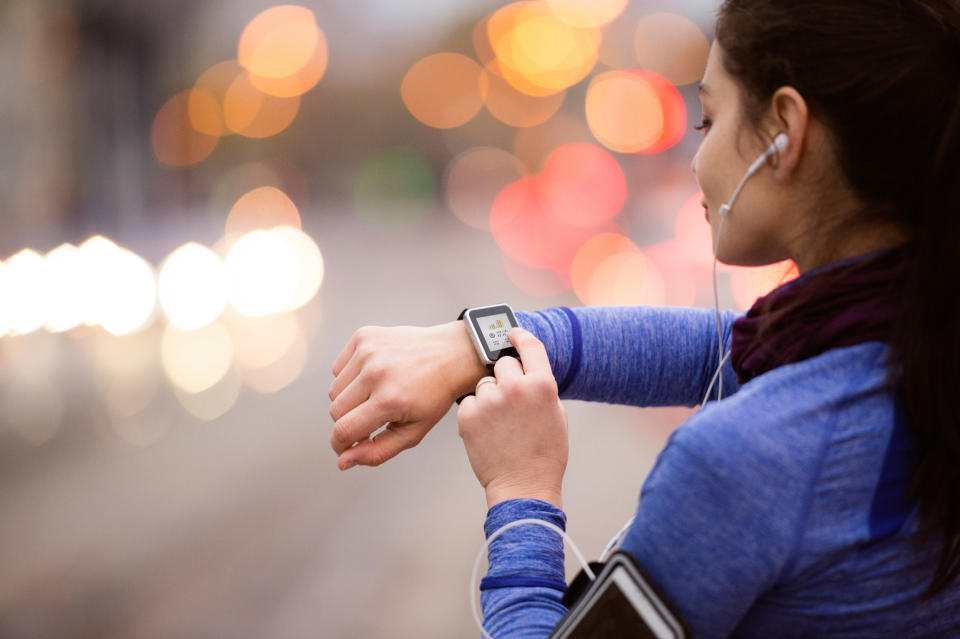 A woman interacts with her smartwatch.