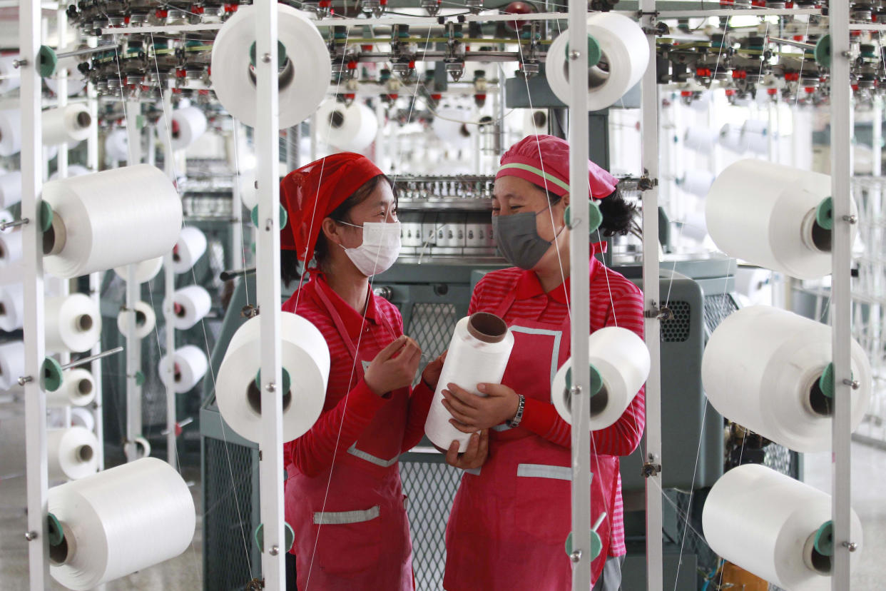 Employees of Songyo Knitwear Factory wearing face masks work Wednesday to produce knitted goods in Songyo district in Pyongyang.  (Jon Chol Jin / AP)