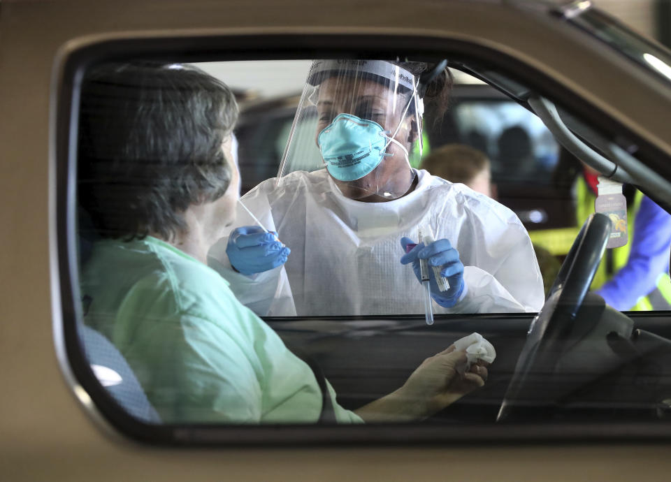 Emory Hospital RN Aisha Bennett takes a nasal swab at a pilot large scale drive-through COVID-19 testing site in the Georgia International Horse Park on Thursday, April 16, 2020, in Conyers, Ga. Testing is by appointment only and open to anyone in the general public who believes they are ill with COVID-19. According to Chad Wasdin, communications director for the Gwinnett Rockdale Newton Health Departments, due to increased testing capacity 400 appointments are scheduled for anyone who thinks they may be ill with the virus. While the Health Department requires a scheduled appointment to test individuals, referral from a doctor is not necessary. There is no charge for the testing, and those tested do not need to provide health insurance information. "We look forward to piloting this large-scale test site," said Dr. Audrey Arona, district health director and CEO of Gwinnett, Newton and Rockdale County Health Departments. "This is a fantastic collaboration between Rockdale and Newton county governments, their EMAs, and the Health Department. Testing will provide individuals in the community an opportunity to learn if their illness is consistent with the COVID-19 virus, and it will help us improve our plans for providing large-scale testing. (Curtis Compton/Atlanta Journal-Constitution via AP)