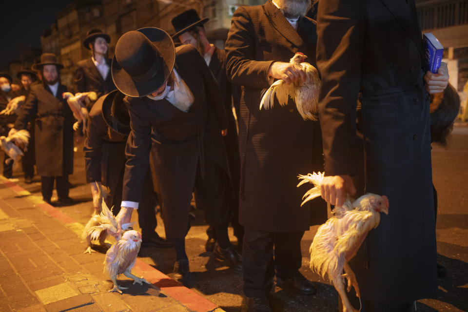 Ultra-Orthodox Jews hold chickens later to be slaughtered during the Kaparot ritual, in Bnei Brak, Israel, Sunday, Sept 27, 2020. Observant Jews believe the ritual transfers one's sins from the past year into the chicken, and is performed before the Day of Atonement, Yom Kippur, the holiest day in the Jewish year which starts at sundown Sunday. The solemn Jewish holiday of Yom Kippur, which annually sees Israeli life grind to a halt, arrived on Sunday in a nation already under a sweeping coronavirus lockdown. (AP Photo/Oded Balilty)