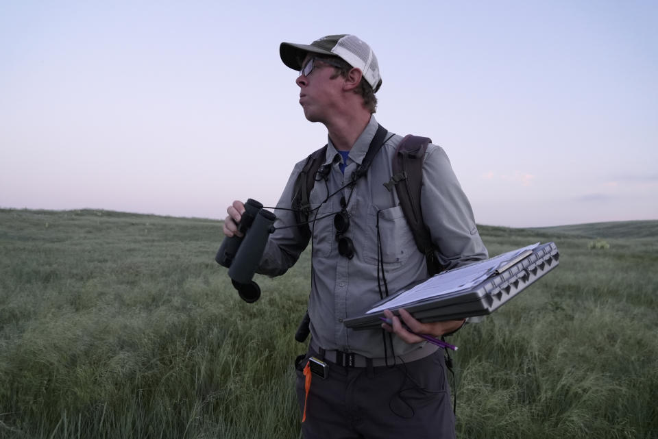 Daniel Horton, field biologist with the Bird Conservancy of the Rockies, conducts a grassland bird survey Tuesday, June 20, 2023, in Potter, Neb. He records everything he sees and hears on grazing land improved by a local rancher. (AP Photo/Brittany Peterson)