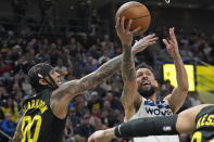 Minnesota Timberwolves guard Austin Rivers (25) goes to the basket as Utah Jazz guard Jordan Clarkson (00) defends during the first half of an NBA basketball game Friday, Dec. 9, 2022, in Salt Lake City. (AP Photo/Rick Bowmer)