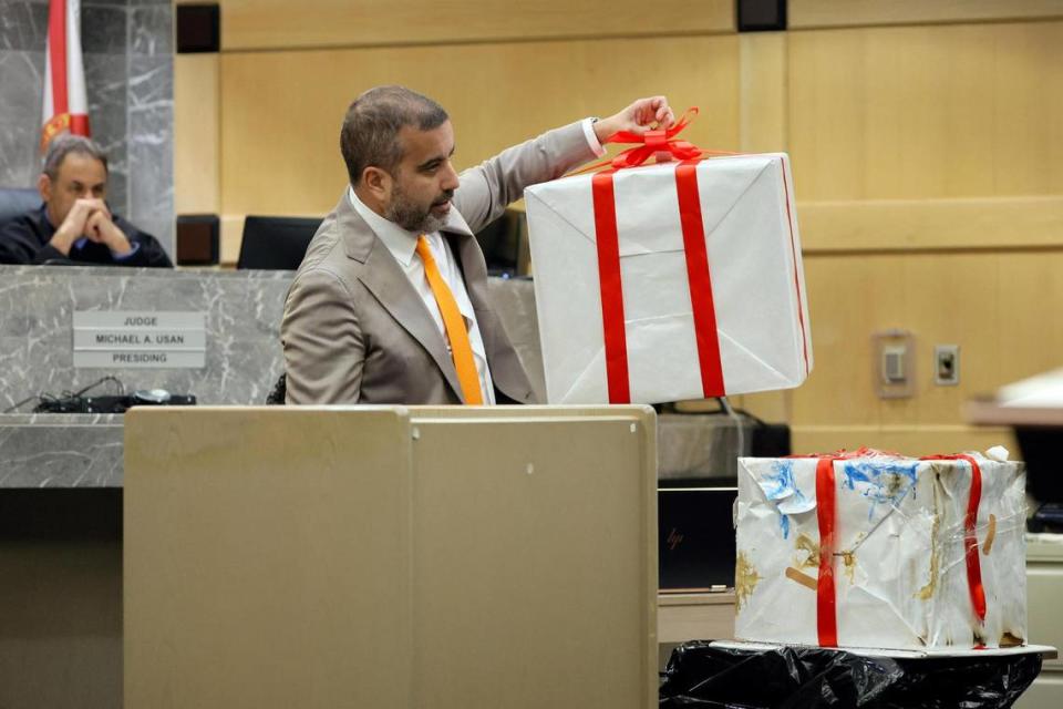 Mauricio Padilla pulls a box neatly wrapped as a giant present off of a smaller box that appears dirty and beaten up that he used as props during his closing argument on behalf of his client, suspected shooting accomplice Dedrick Williams, in the XXXTentacion murder trial at the Broward County Courthouse in Fort Lauderdale on Tuesday, March 7, 2023. Judge Michael Usan looks on. Padilla implied that the prosecution was presenting its case as the beautifully wrapped package but really, it was the dirty beaten-up one. Emerging rapper XXXTentacion, born Jahseh Onfroy, 20, was killed during a robbery outside of Riva Motorsports in Deerfield Beach in 2018 allegedly by defendants Michael Boatwright, Trayvon Newsome and Dedrick Williams.