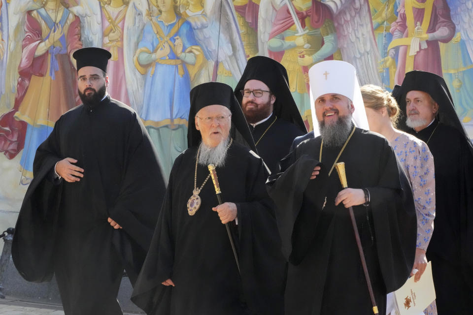 FILE - Ecumenical Patriarch Bartholomew I, center, accompanied by the head of the Ukrainian Church Metropolitan Epiphanius, right, visits the Mikhailovsky Zlatoverkhy Cathedral (St. Michael's Golden-Domed Cathedral) in Kyiv, Ukraine, on Aug. 21, 2021. Ukrainians usually celebrate Christmas on Jan. 7, as do Russians, but some Orthodox Ukrainians have decided to observe Christmas of 2022 on Dec. 25, like many Christians around the world. (AP Photo/Efrem Lukatsky, File)