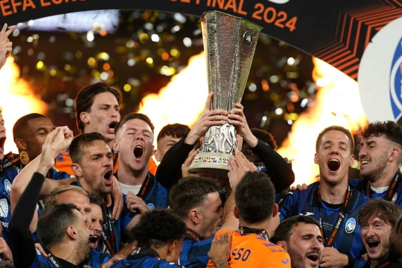 Atalanta players celebrate the title with the trophy after the UEFA Europa League final soccer match between Atalanta Bergamo and Bayer Leverkusen at the Aviva Stadium. Brian Lawless/PA Wire/dpa