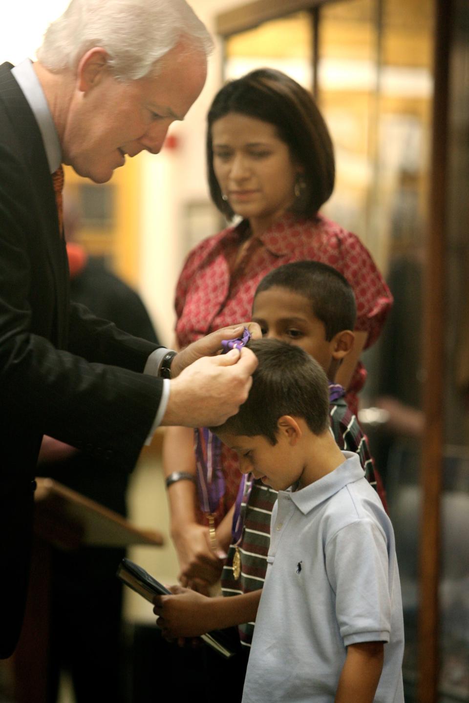 Nov. 12, 2007: Sen. John Cornyn, R-Texas, left, presented a Gold Medal of Remembrance to Nathan Locklear, 6, on Sunday at Fort Bliss. Locklear, whose father, Sgt. Velton Locklear III, was killed Sept. 23, 2006, in Iraq was among children from three families honored with the Gold Medals that are presented to the children of soldiers killed in action.