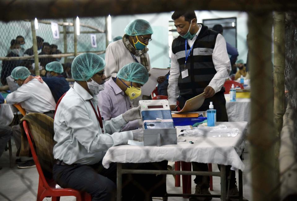 Election officers wearing face masks count votes for the Bihar state assembly polls, at a counting centre in Patna, India, Tuesday, Nov. 10, 2020. (AP Photo/Aftab Alam Siddiqui)