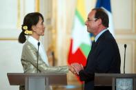 France's President Francois Hollande (R) shakes hands with Myanmar pro-democracy leader Aung San Suu Kyi after a press conference at the Elysee presidential palace in Paris. Hollande told Suu Kyi Tuesday that France would do everything possible to back the country's democratic transition, as she visited Paris for the last leg of a landmark European tour