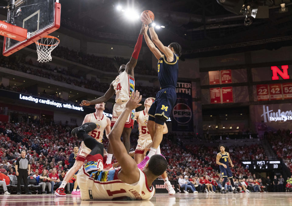 Michigan's Olivier Nkamhoua, right, shoots against Nebraska's Juwan Gary, second left, during the second half of an NCAA college basketball game, Saturday, Feb. 10, 2024, in Lincoln, Neb. (AP Photo/Rebecca S. Gratz)