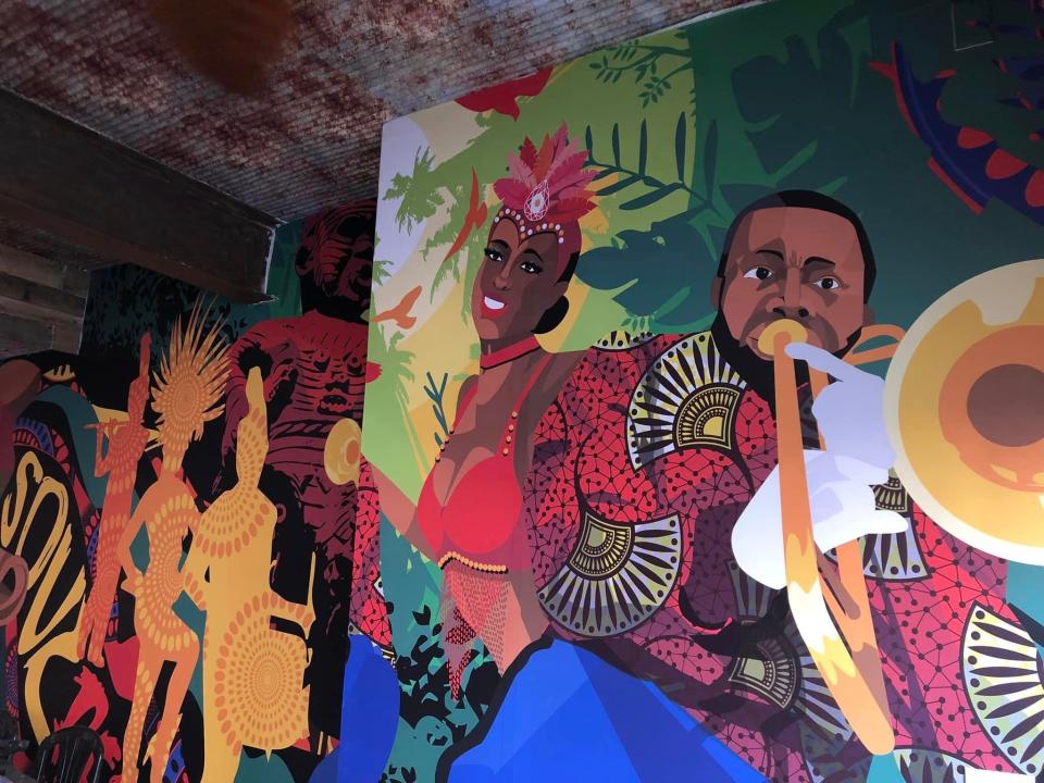 A Caribbean carnival and American marching band-themed mural inside Soul Rebel restaurant in Old Towne Petersburg.