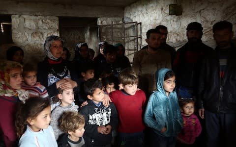 People take cover in a cellar in the village of Qastal Koshk, north of Afrin  - Credit: AFP