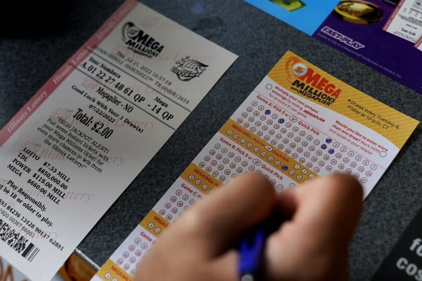 A customer fills out a Mega Millions lottery ticket at a convenience store Thursday, July 21, 2022, in Northbrook, Ill. Lottery officials have raised the Mega Millions grand prize to $660 million Thursday, July 21, 2022, giving players a shot at the nation's ninth largest jackpot. (AP Photo/Nam Y. Huh)