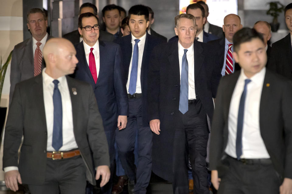 U.S. Treasury Secretary Steven Mnuchin, center left, and U.S. Trade Representative Robert Lighthizer, center right, walk together as they leave their hotel in Beijing, Friday, Feb. 15, 2019. U.S. and Chinese negotiators opened talks Thursday on a sprawling trade dispute as Beijing reported its January exports rebounded despite President Donald Trump's tariff hikes. (AP Photo/Mark Schiefelbein)