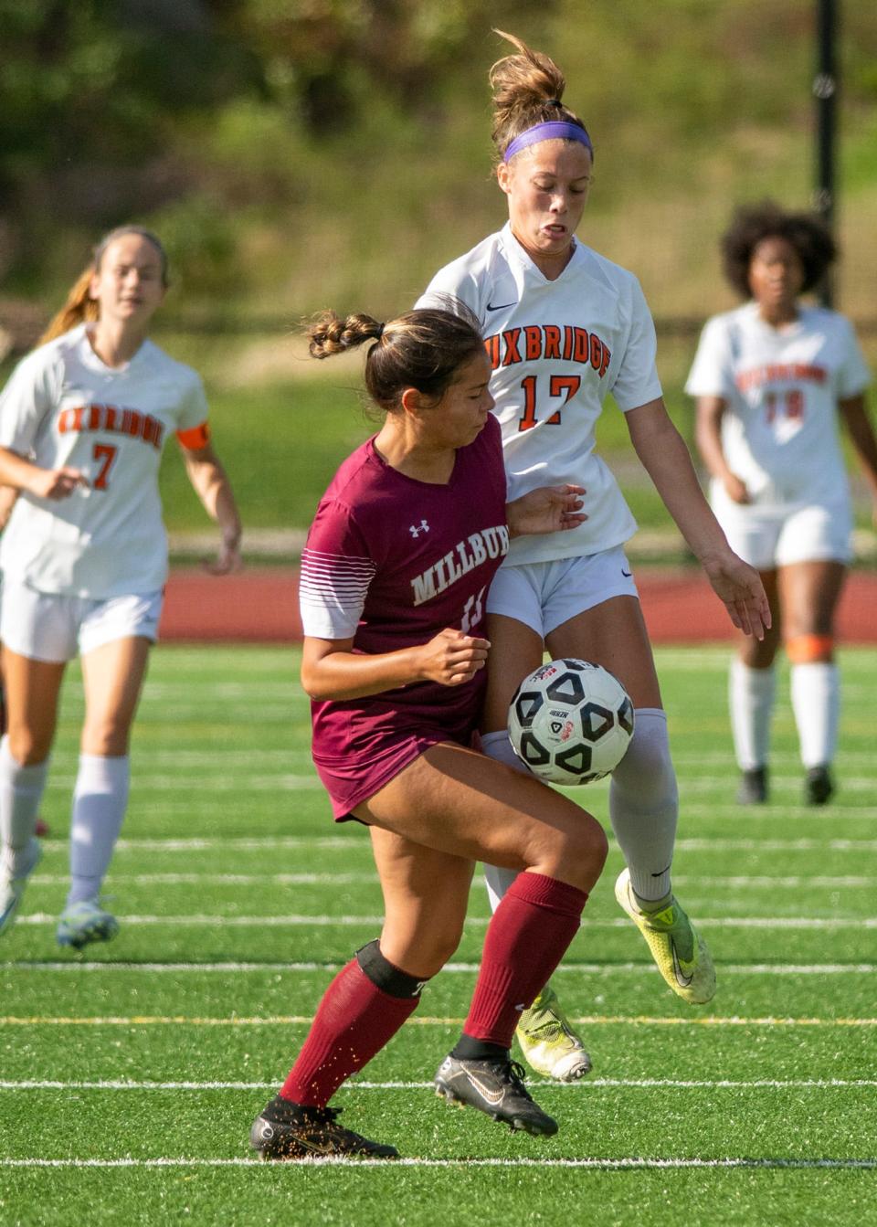 Millbury's Maya Bravo and Uxbridge's Kathryn Cahill go after a loose ball during Wednesday's game.