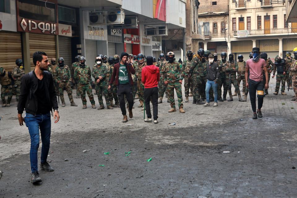 Anti-government protesters and security forces face-off on Rasheed Street in Baghdad, Iraq, Sunday, Dec. 1, 2019. Iraq’s parliament approved the resignation of Prime Minister Adel Abdul-Mahdi, amid ongoing violence and anti-government demonstrations. (AP Photo/Khalid Mohammed)