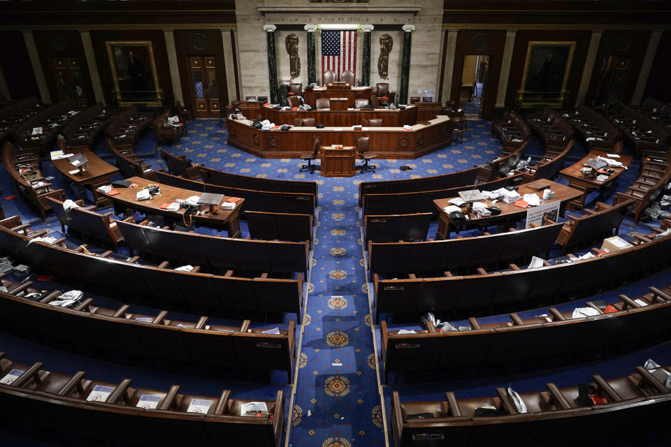 FILE - In this Jan. 6, 2021 file photo, the House Chamber is empty after a hasty evacuation as rioters tried to break into the chamber at the U.S. Capitol in Washington. President Joe Biden’s first address to Congress is an invite-only affair, and no guests allowed. The restrictions for Wednesday’s event are due to COVID-19 safety protocols, but will have the added security benefit of a limited number of people inside the Capitol for the president’s first major indoor event since he took office just weeks after the Jan. 6 insurrection. The fence is still up around the U.S. Capitol, and the National Guard is still there. (AP Photo/J. Scott Applewhite)