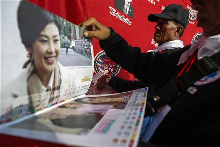 Members of the "Volunteers' Ward to protect the Nation's Democracy" group hold pictures of Thailand's Prime Minister Yingluck Shinawatra during their two days training at the stadium in Nakhon Ratchasima, Northeastern province of Thailand, April 21, 2014. REUTERS/Athit Perawongmetha