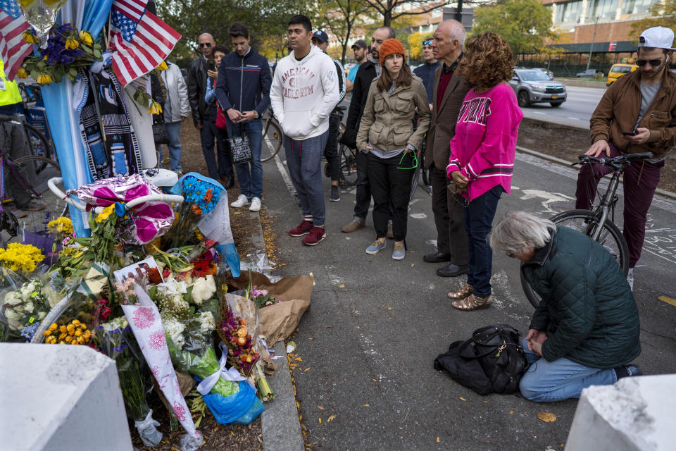 FILE - A group pauses, with some in prayer, at a makeshift memorial on a New York City bike path, on Nov. 4, 2017, that that honors victims of an attack who were stuck and killed by a rental truck driven by indicted suspect Sayfullo Saipov. Saipov, an Islamic extremist who killed eight in a New York bike path attack was convicted of federal crimes on Thursday, Jan. 26, 2023, and could face the death penalty. (AP Photo/Craig Ruttle)